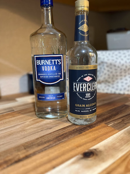 two bottles of alcohol sitting on a counter top